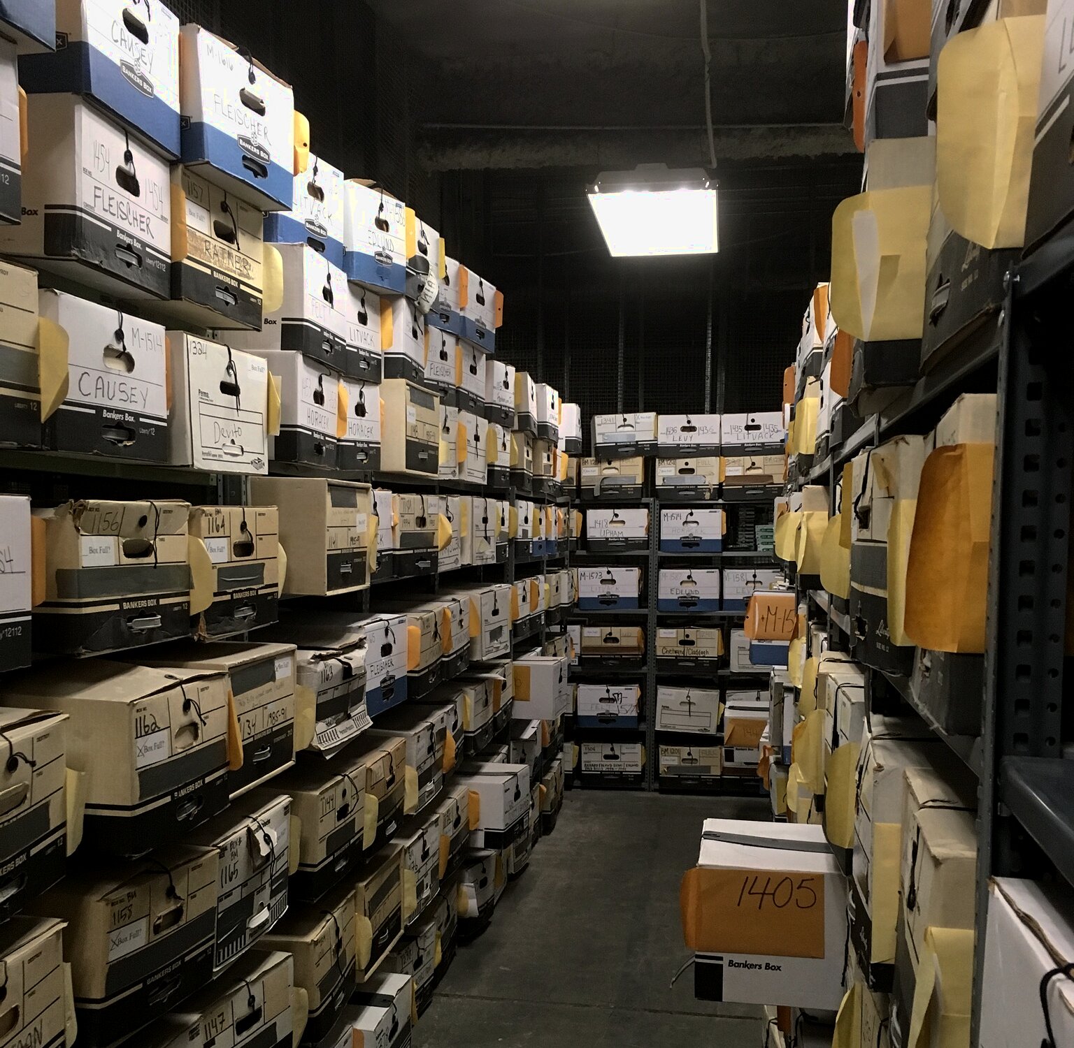 Rows of archival file boxes in a records storage room.